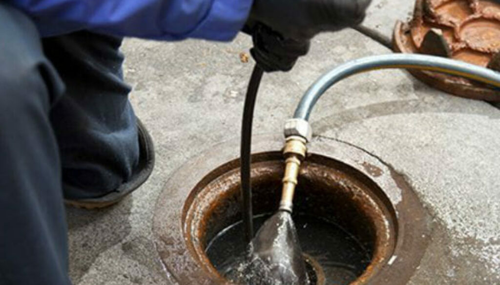 Professional drain cleaner cleaning a drain, for maintenance purposes in Newbury and Reading.